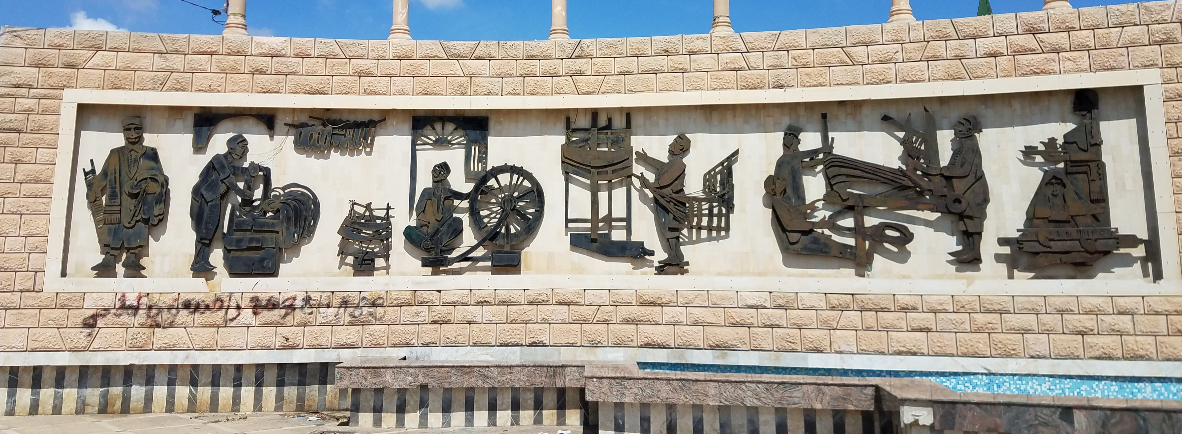 Metal sculptures in a Tunisian village illustrating the weaving process once used in ancient times, now used to create cotton towels and oversized beach towels.