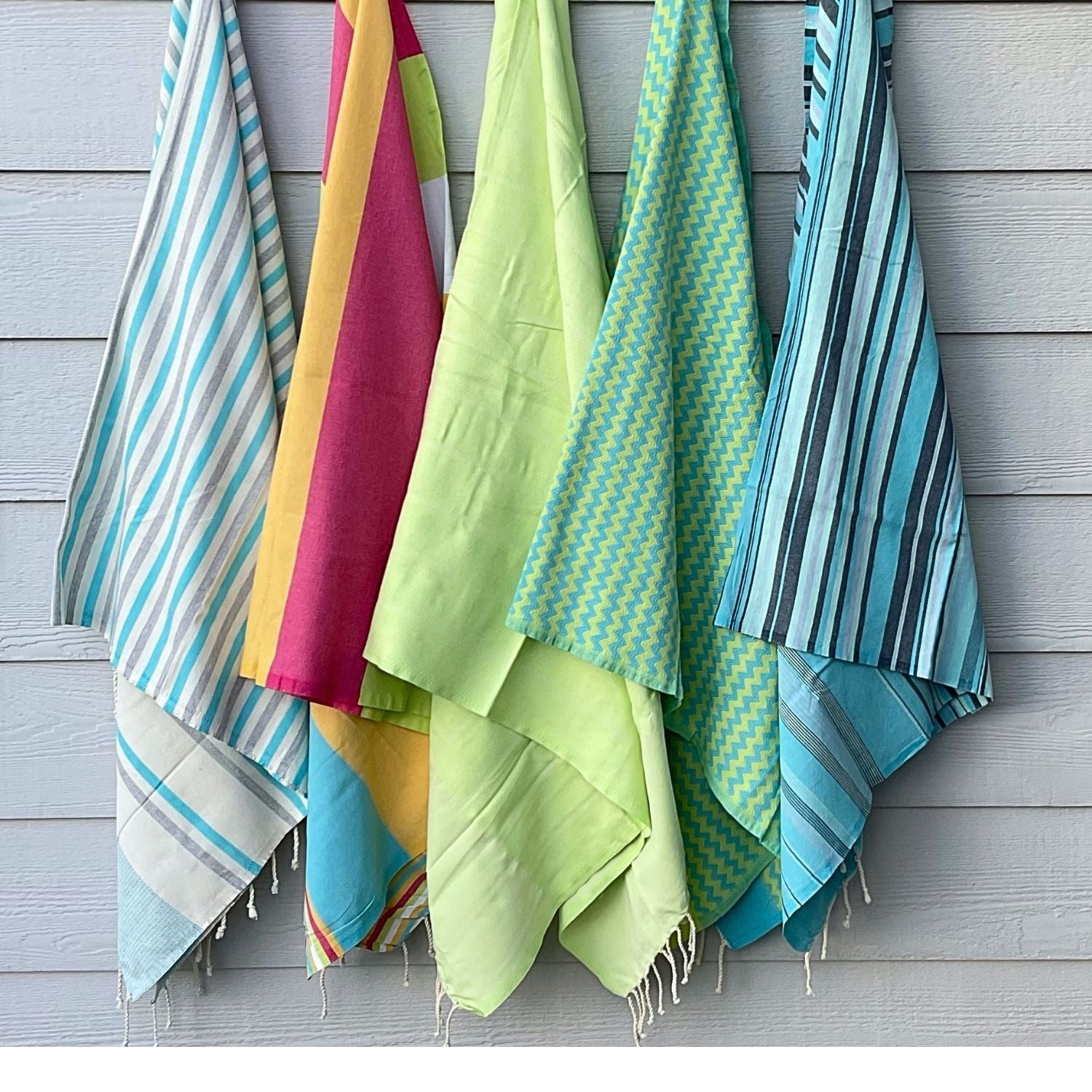 collection of fouta towels in coastal colors including lime green blue and striped patterns lightweight cotton towels