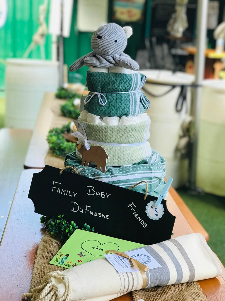 Hand towels creatively layered with diapers to form a baby shower "cake"—a unique and practical gift idea.