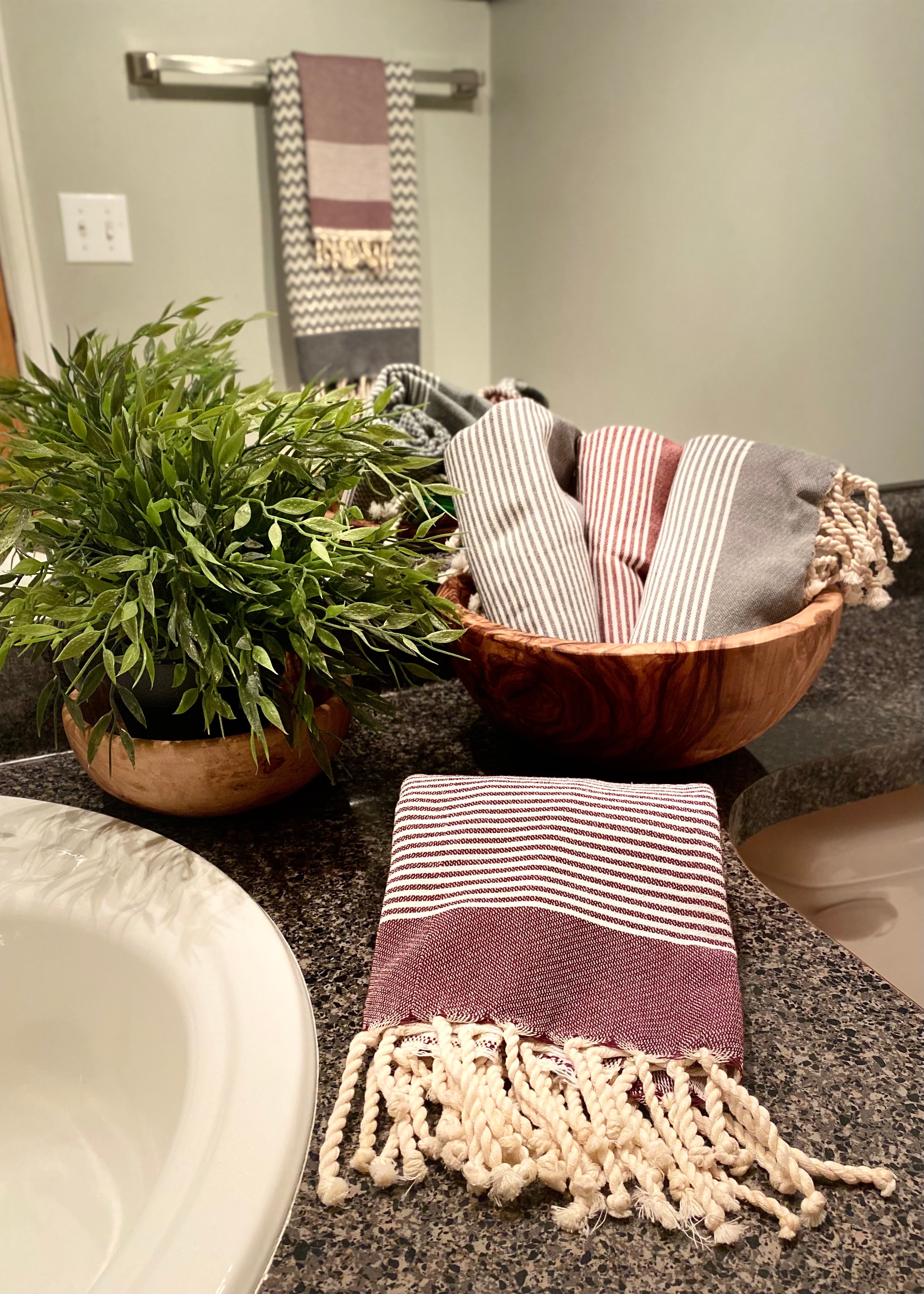 Aubergine and gray bath hand towels neatly folded on a bathroom counter, adding soft texture and style to your everyday decor.