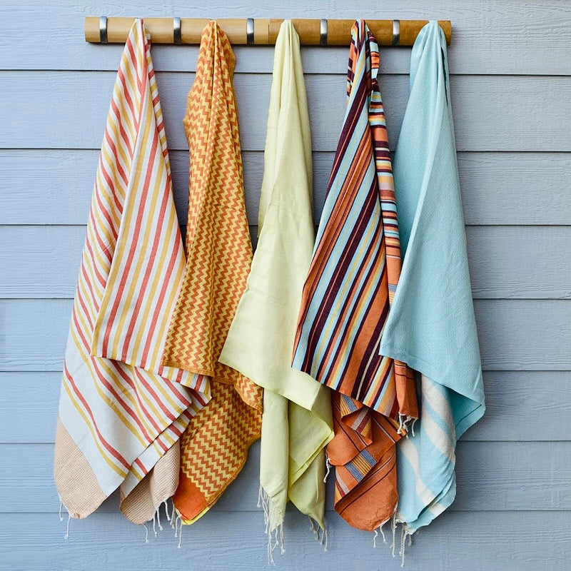 Hanging colorful woven cotton towels in various patterns and hues, perfect unique gifts for any home.