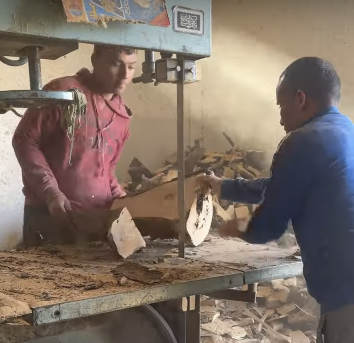 Ahmed and Hassan trimming a large chunk of wood on a band saw in their Tunisian workshop — collaborative work behind handcrafted gifts ideas.